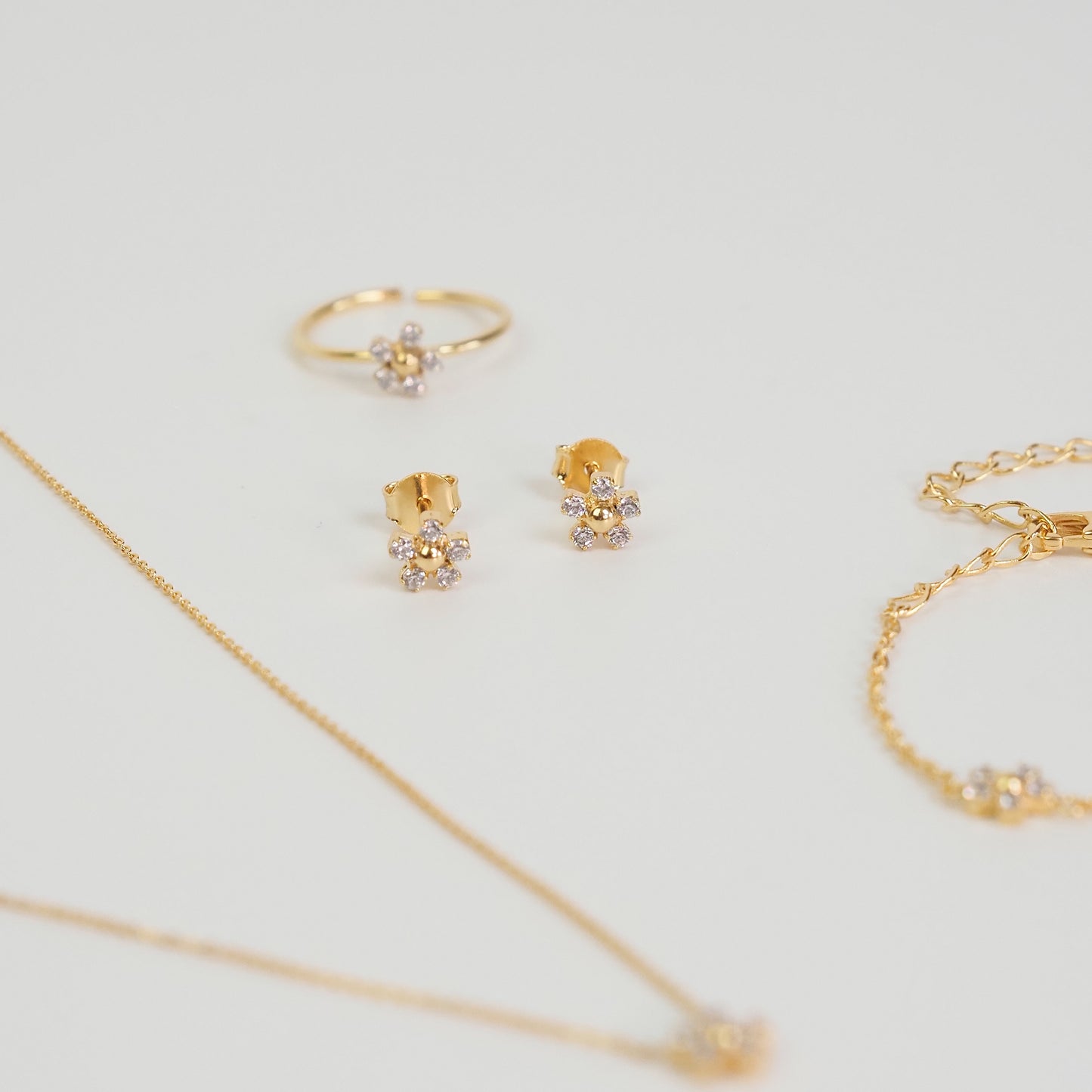 Brinco flor zirconia dourado