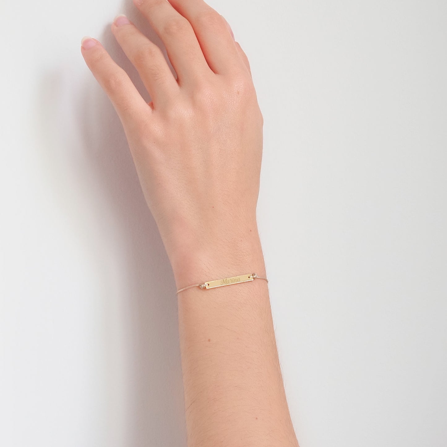 Pulseira inicial plaquinha creme dourada