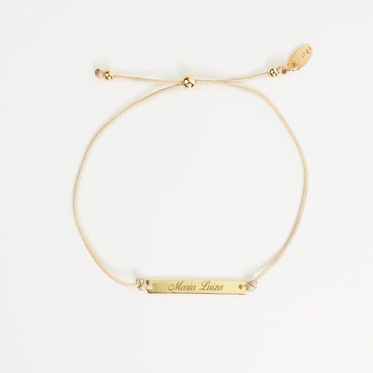 Pulseira inicial plaquinha creme dourada