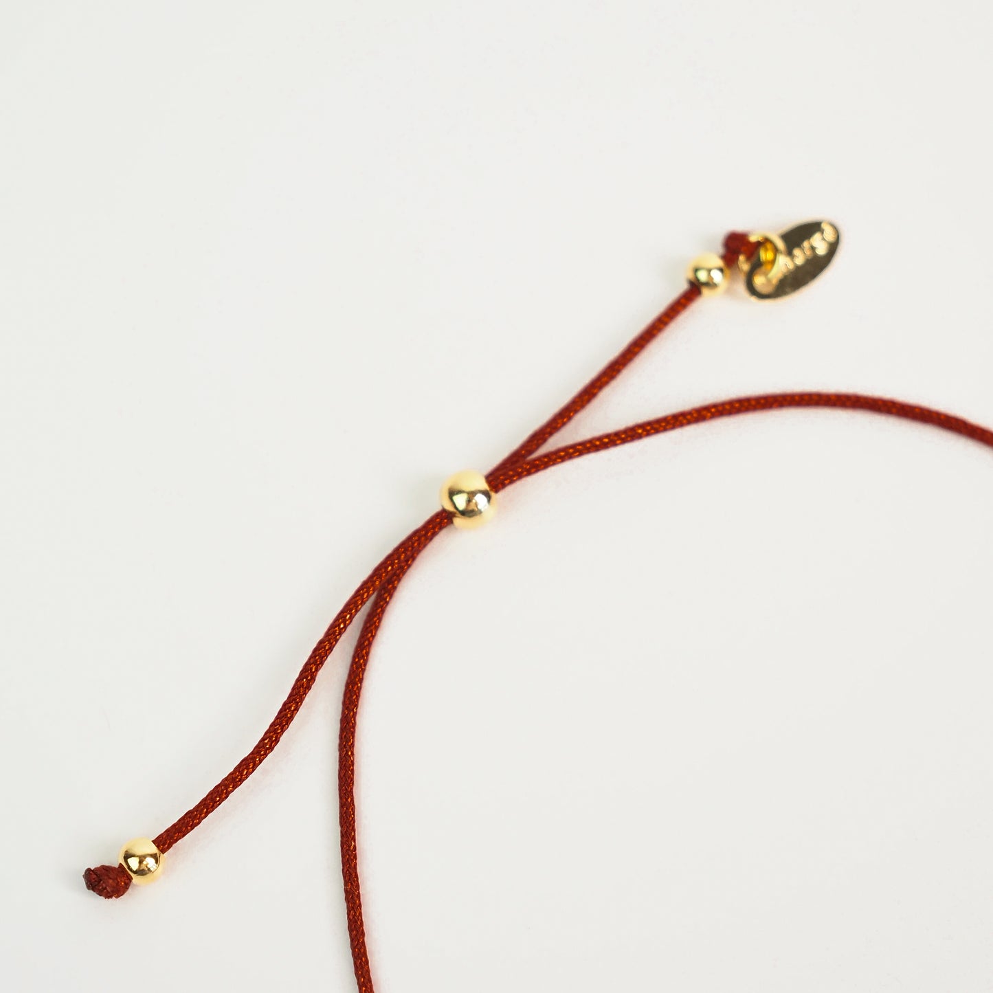 Pulseira inicial plaquinha bordô dourada